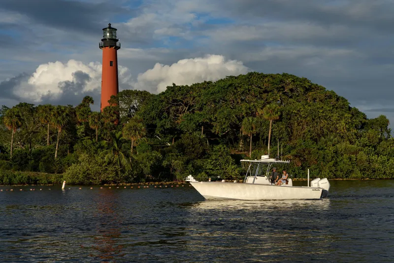 Slide: The Image of Valhalla Boatworks V-29 Hybrid cruising near a lighthouse, lush greenery in the background. - 3