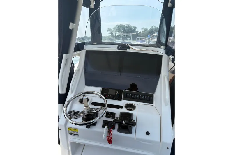 Slide: The Image of Helm of 2015 Regulator 25 boat with steering wheel and control panel. - 12
