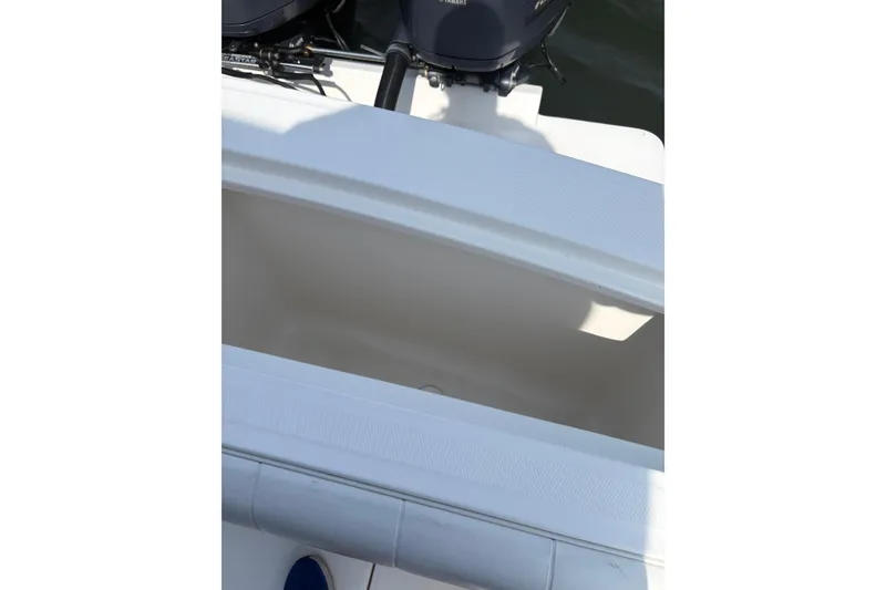 Slide: The Image of 2015 Regulator 25 boat interior with visible storage compartment and dual outboard motors. - 10