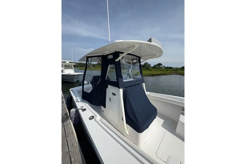 Slide: The Image of 2015 Regulator 25 boat docked by the water with protective covers. - 14