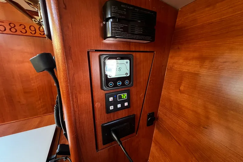 Slide: The Image of Control panel inside a 2015 Hunter 37 yacht, featuring digital displays and wooden interior. - 49