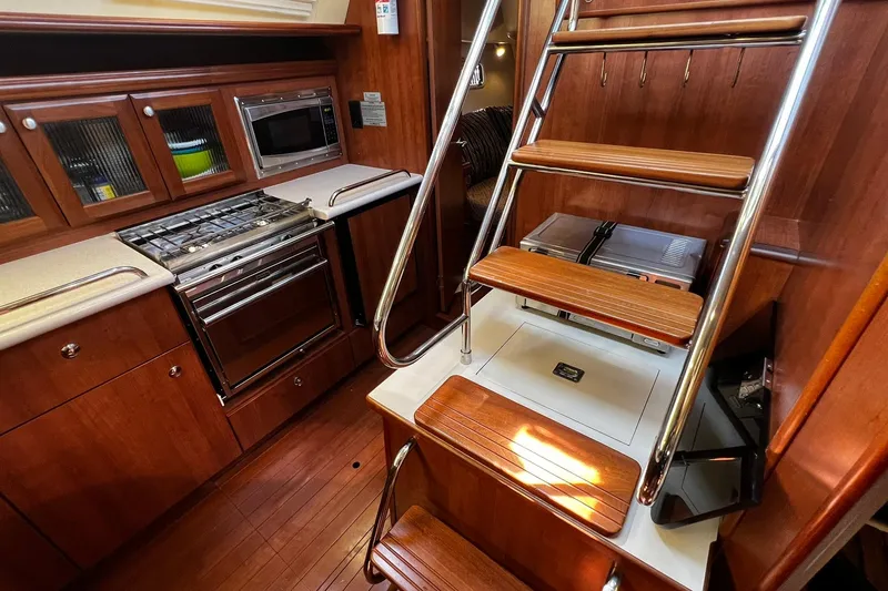 Slide: The Image of Interior of 2015 Hunter 37 yacht kitchen with wooden cabinetry and stainless steel appliances. - 19