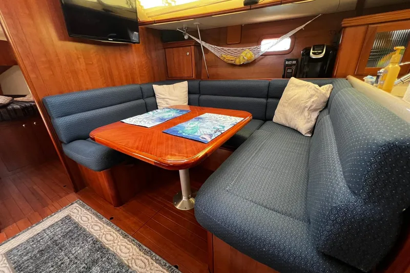 Slide: The Image of Cozy interior of a 2015 Hunter 37 sailboat with blue seating and wooden table. - 43