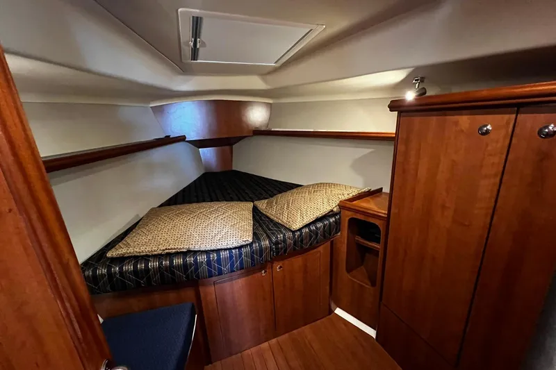 Slide: The Image of Cozy cabin interior of 2015 Hunter 37 sailboat with wooden furnishings and bedding. - 45