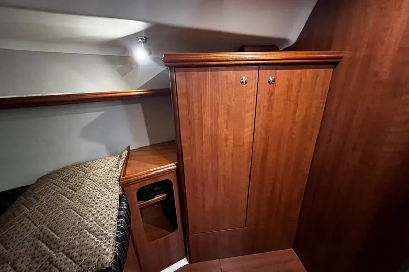 Slide: The Image of Cozy cabin interior of 2015 Hunter 37 sailboat with wooden cabinetry and bedding. - 46