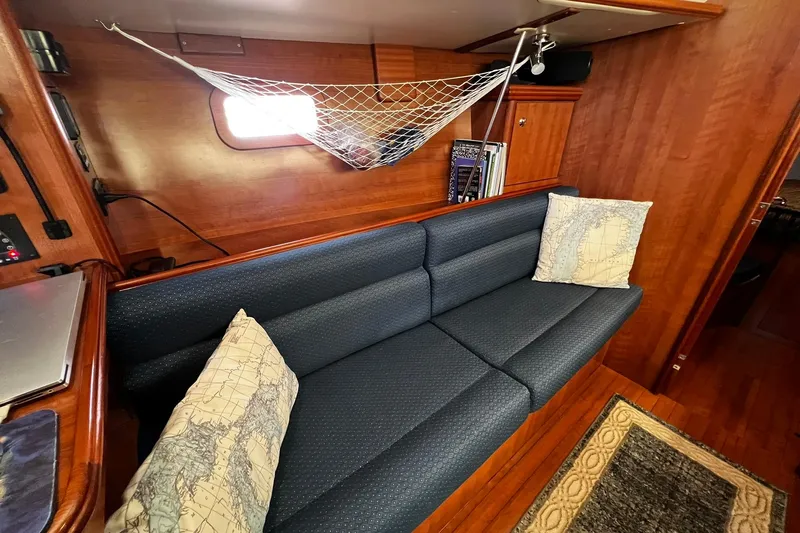 Slide: The Image of Interior of 2015 Hunter 37 sailboat with blue sofa, map pillows, and wooden finish. - 41