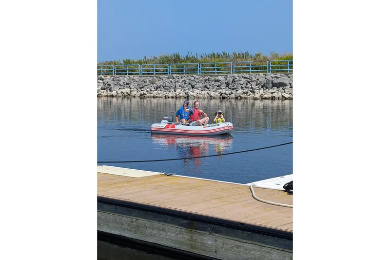 Slide: The Image of Family enjoying a ride on a Hunter 37 inflatable boat near a dock. - 60