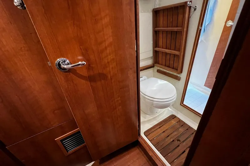 Slide: The Image of Bathroom interior of a 2015 Hunter 37 yacht, featuring wooden accents and a compact toilet. - 31