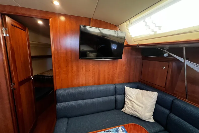 Slide: The Image of Interior of 2015 Hunter 37 yacht with wood paneling, TV, and blue seating area. - 44