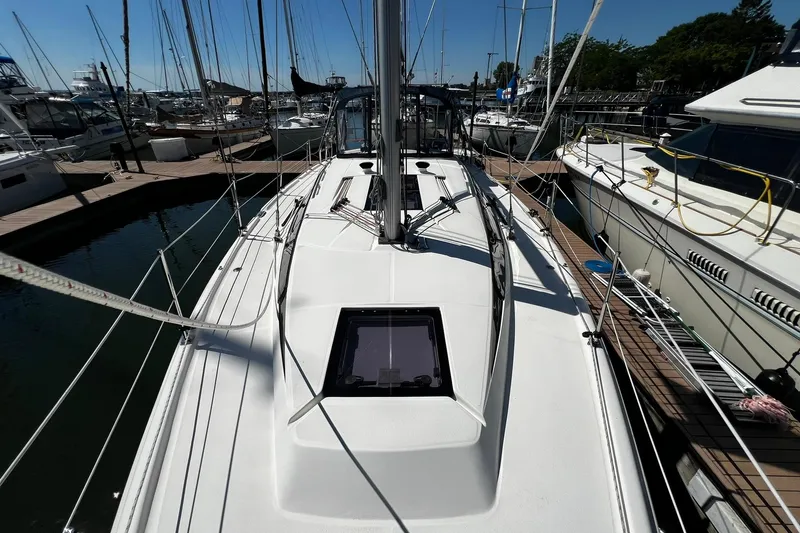 Slide: The Image of 2015 Hunter 37 sailboat docked at marina, showcasing sleek deck design and rigging. - 14