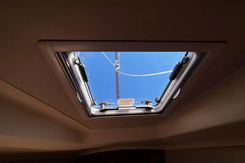 Slide: The Image of Ceiling hatch view from a 2015 Hunter 37 sailboat, showcasing clear blue sky. - 51