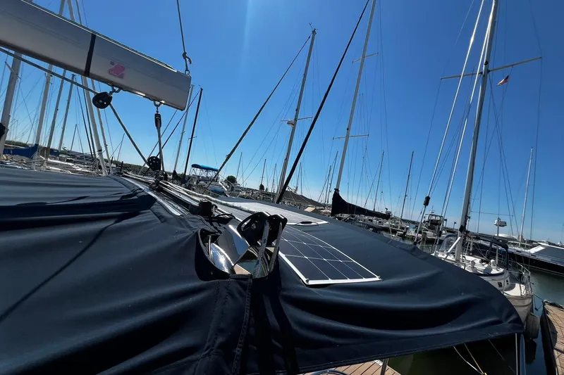 Slide: The Image of 2015 Hunter 37 sailboat with solar panel, docked in a marina under clear blue sky. - 17