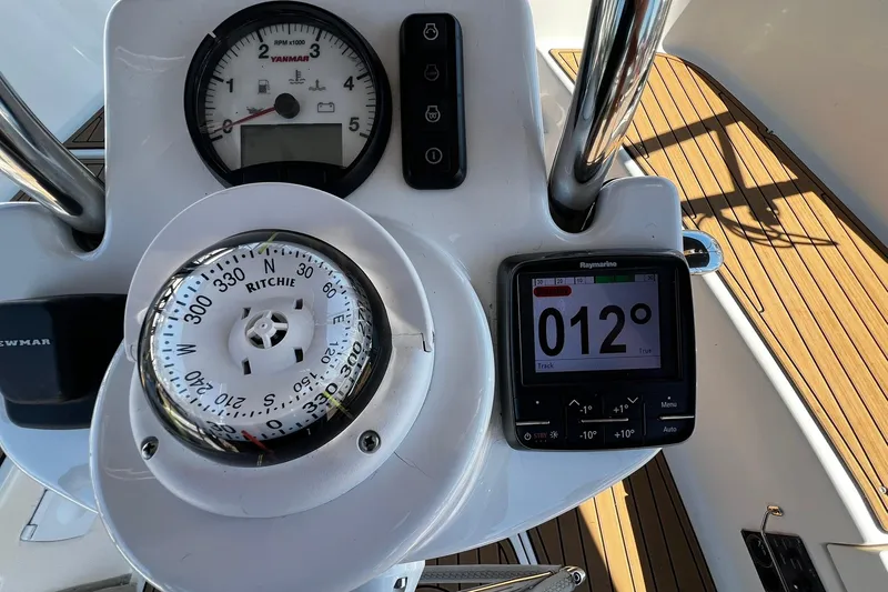 Slide: The Image of Cockpit instruments of a 2015 Hunter 37 sailboat, featuring compass and navigation display. - 6