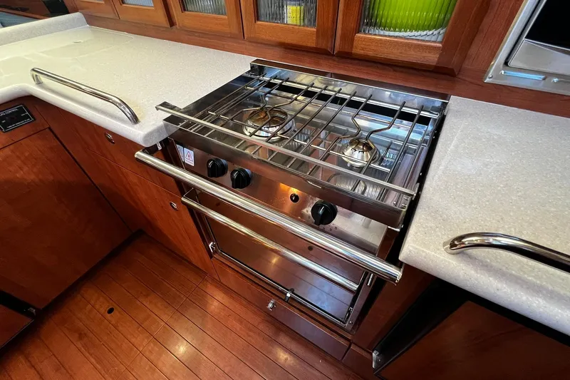 Slide: The Image of Modern kitchen in 2015 Hunter 37 yacht with stainless steel stove and wooden cabinetry. - 21