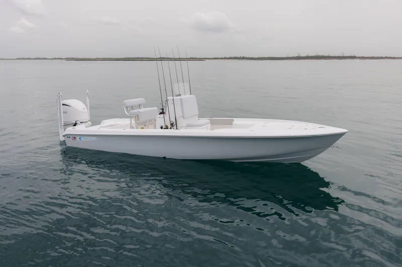 The Image of 2026 Contender 24 Bay boat on calm water, equipped with fishing rods. - 1