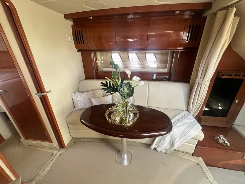 Slide: The Image of Interior of a 2006 Sea Ray 380 Sundancer with an elegant seating area and wooden table. - 8