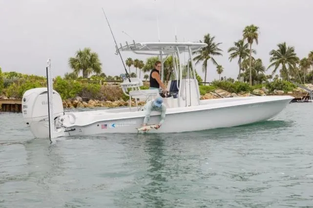 Slide: The Image of 2027 Contender 26 Bay boat on water with palm trees in background. - 3