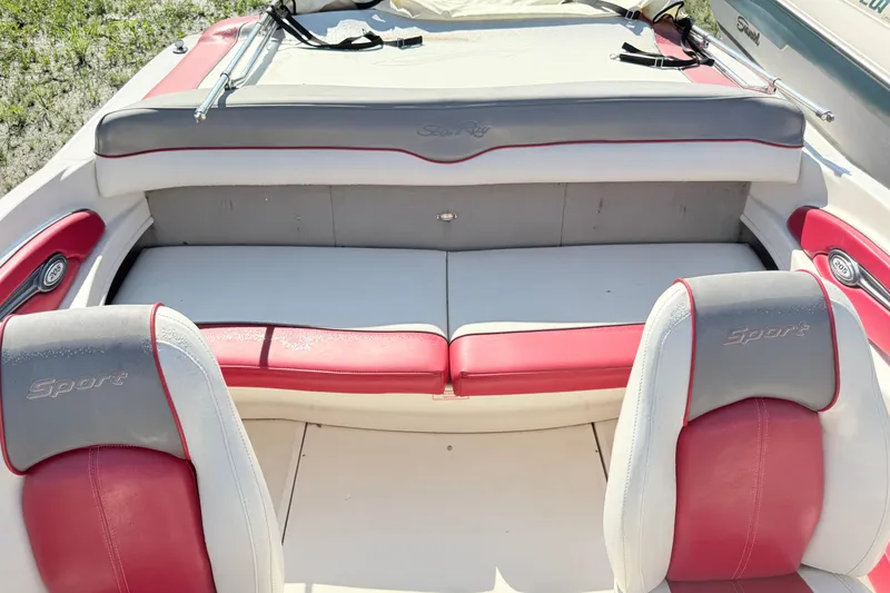 Slide: The Image of 2006 Sea Ray 210 Bow Rider interior with red and gray seating, showcasing sporty design. - 9