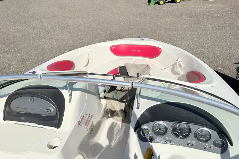 Slide: The Image of 2006 Sea Ray 210 Bow Rider boat interior with red seating and dashboard controls. - 5