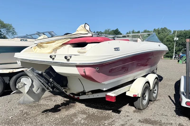 Slide: The Image of 2006 Sea Ray 210 Bow Rider boat on trailer, parked outdoors on gravel. - 4