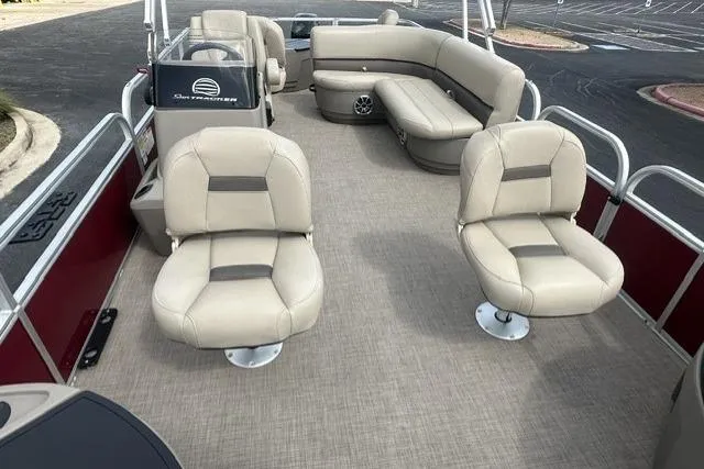 Slide: The Image of 2025 Sun Tracker Bass Buggy 18 DLX pontoon boat interior with beige seating and spacious layout. - 3