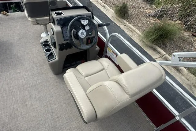 Slide: The Image of 2025 Sun Tracker Bass Buggy 18 DLX helm with beige captain's chair and steering console. - 7