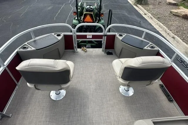 Slide: The Image of 2025 Sun Tracker Bass Buggy 18 DLX pontoon boat interior with swivel seats and storage compartments. - 6