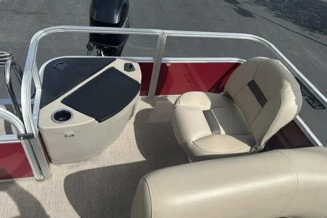 Slide: The Image of 2025 Sun Tracker Bass Buggy 18 DLX pontoon boat interior with beige seating and console. - 9