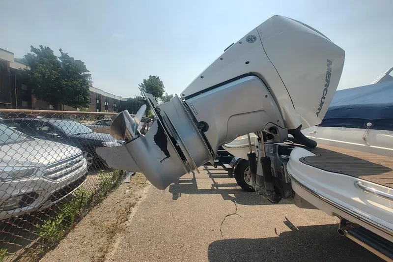 Slide: The Image of Damaged Mercury outboard motor on a 2021 Sea Ray SDX 270 boat, parked outdoors. - 6