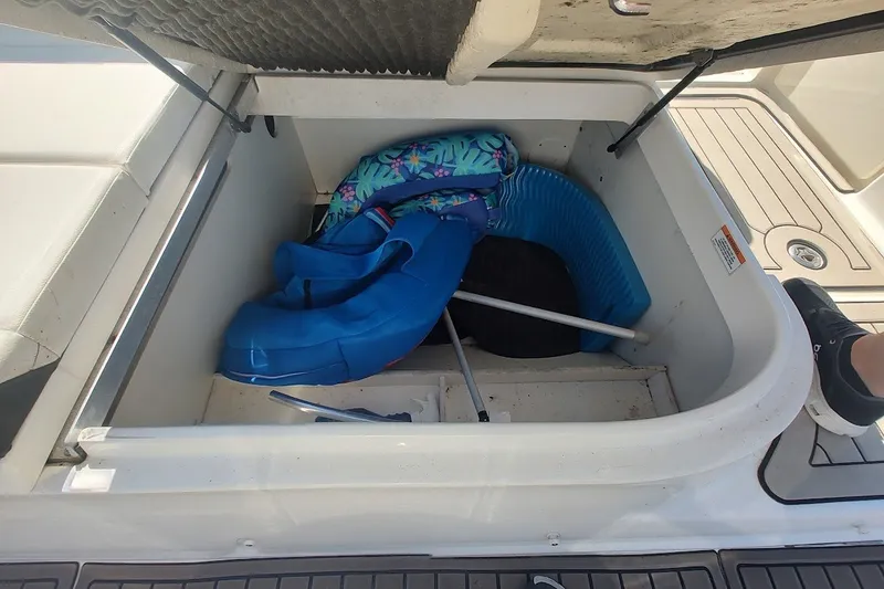 Slide: The Image of Storage compartment of 2021 Sea Ray SDX 270 Outboard with life jackets and equipment. - 25