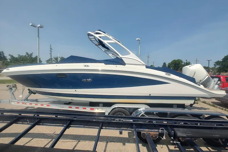 Slide: The Image of 2021 Sea Ray SDX 270 Outboard boat on trailer, blue and white design, sunny day. - 2