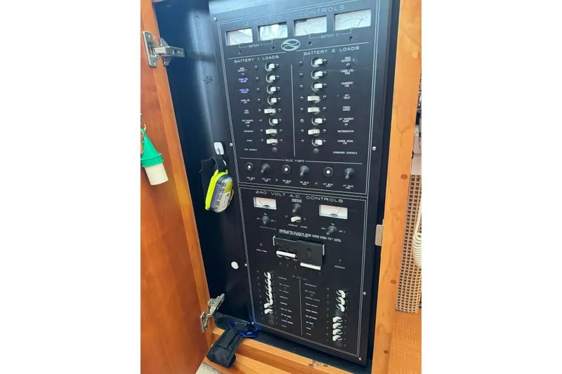 Slide: The Image of Electrical control panel inside a 2002 Silverton 392 Motor Yacht, featuring various switches and meters. - 46
