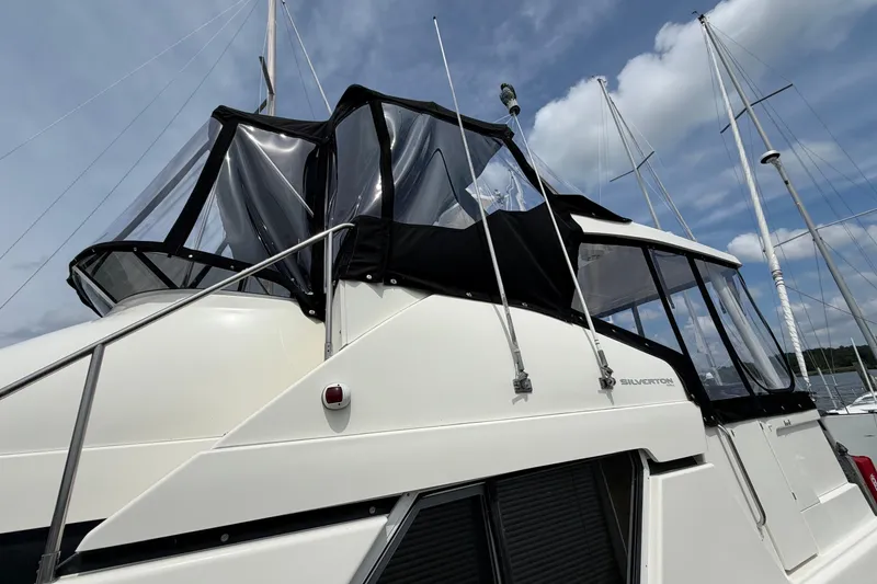 Slide: The Image of 2002 Silverton 392 Motor Yacht with black canopy, docked under a blue sky. - 4