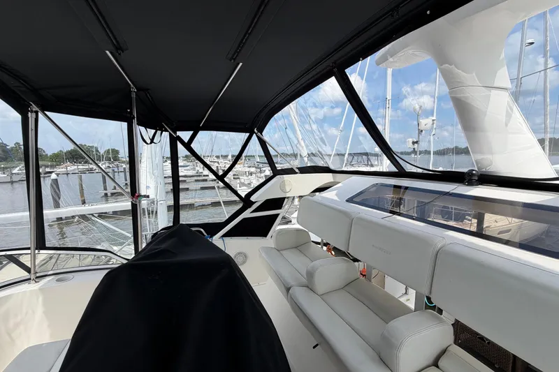 Slide: The Image of 2002 Silverton 392 Motor Yacht interior with marina view, featuring white seating and black canopy. - 14