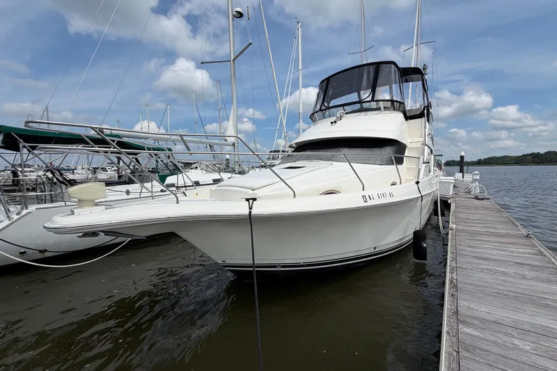 Slide: The Image of 2002 Silverton 392 Motor Yacht docked at marina under blue sky. - 2