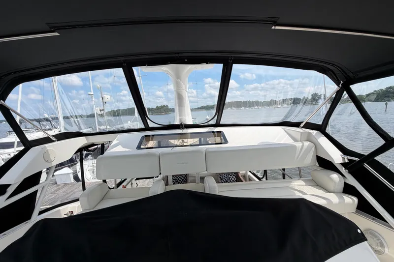 Slide: The Image of Interior view of 2002 Silverton 392 Motor Yacht with white seating and panoramic windows. - 13