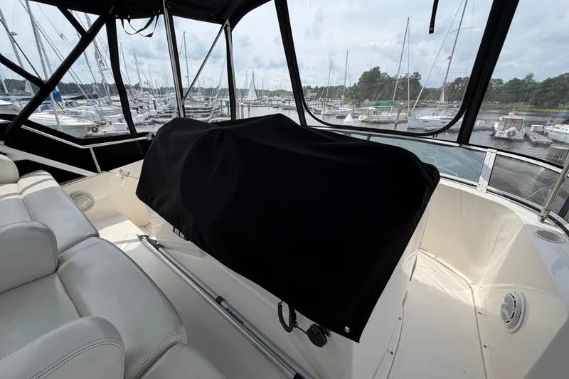 Slide: The Image of 2002 Silverton 392 Motor Yacht interior with covered helm, marina view in background. - 15