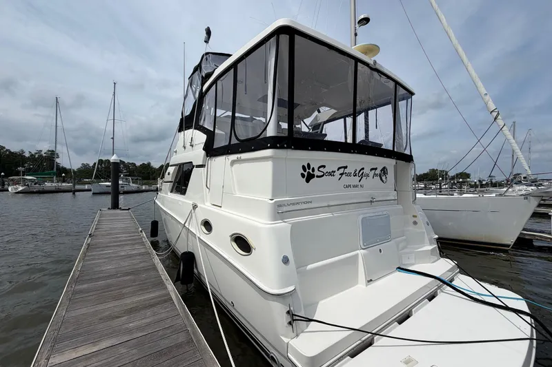 The Image of 2002 Silverton 392 Motor Yacht docked at marina, featuring spacious aft deck and sleek design. - 1
