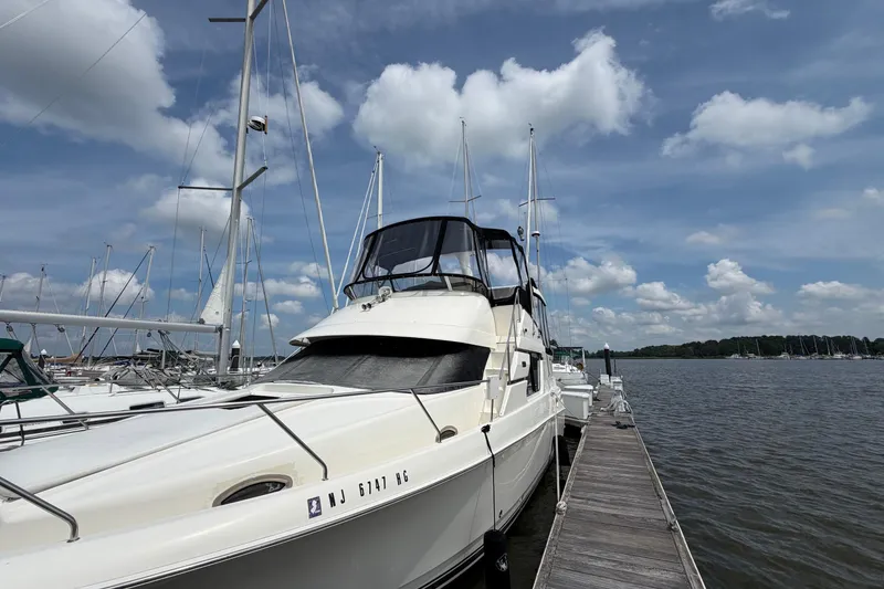 Slide: The Image of 2002 Silverton 392 Motor Yacht docked at a marina under a partly cloudy sky. - 3