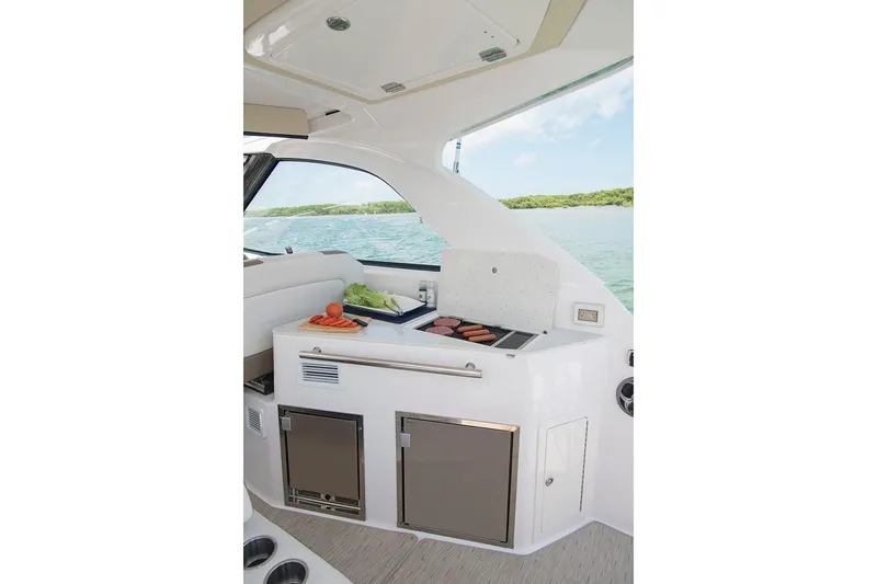 Slide: The Image of Manufacturer Provided Image: 2019 Regal 35 Sport Coupe yacht interior with kitchenette and scenic water view. - 8