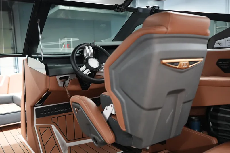 Slide: The Image of Interior of 2025 Nautique Super Air Nautique G23 boat, featuring sleek steering and luxurious seating. - 15