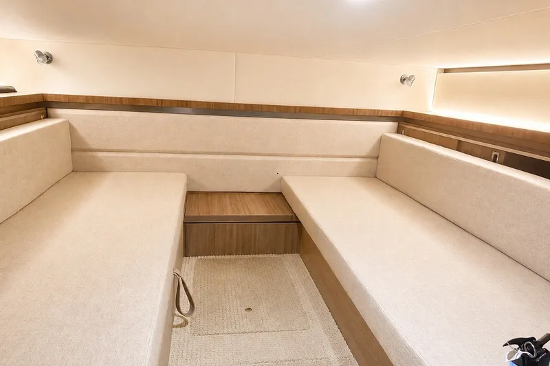 Slide: The Image of Interior cabin of 2022 Sea Ray Sundancer 320 Coupe Outboard, featuring beige seating and wood accents. - 37