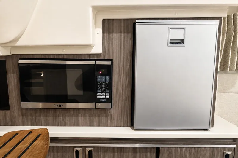 Slide: The Image of Microwave and fridge in 2022 Sea Ray Sundancer 320 Coupe Outboard interior kitchen. - 33