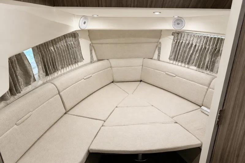 Slide: The Image of Interior of 2022 Sea Ray Sundancer 320 Coupe Outboard, featuring a cozy, beige seating area. - 36