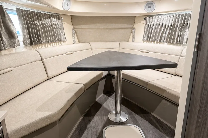 Slide: The Image of Interior of 2022 Sea Ray Sundancer 320 Coupe Outboard with beige seating and triangular table. - 34