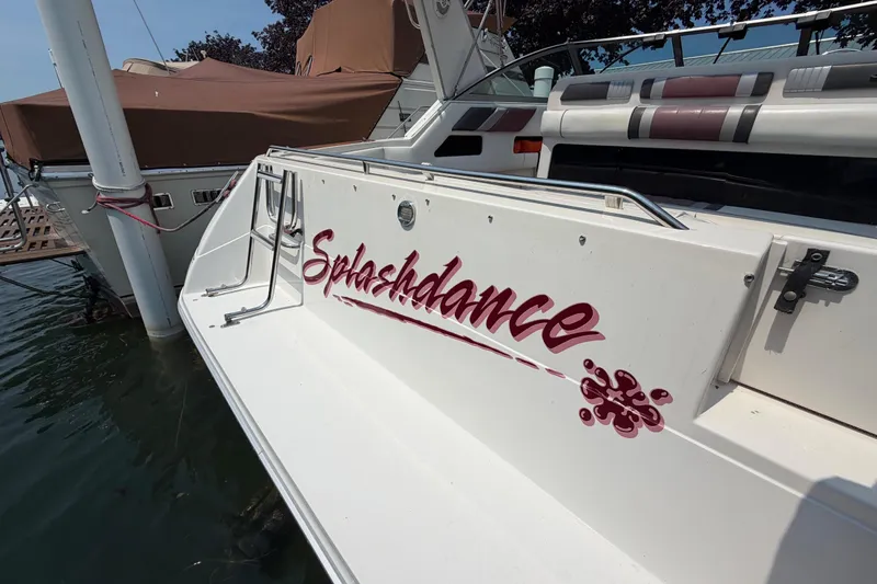 Slide: The Image of 1989 Sea Ray Sundancer 280 boat with "Splashdance" name on the stern, docked in water. - 9