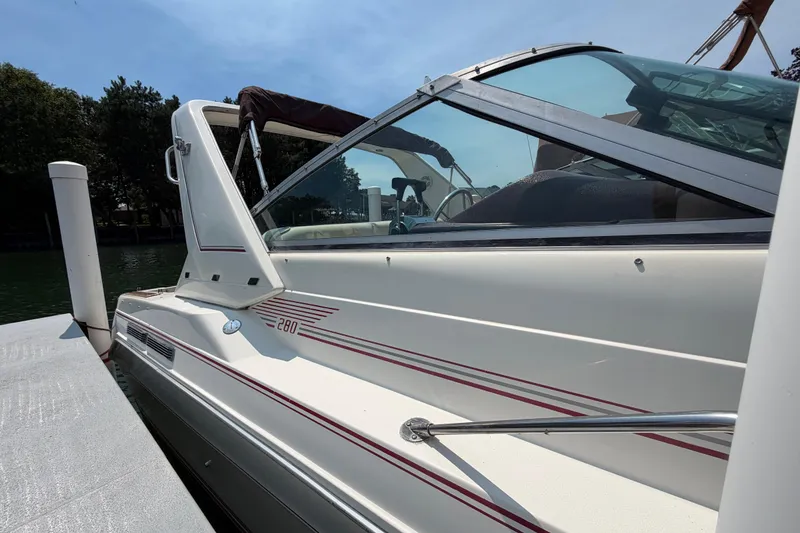 Slide: The Image of 1989 Sea Ray Sundancer 280 docked, showcasing sleek design and classic white exterior. - 7