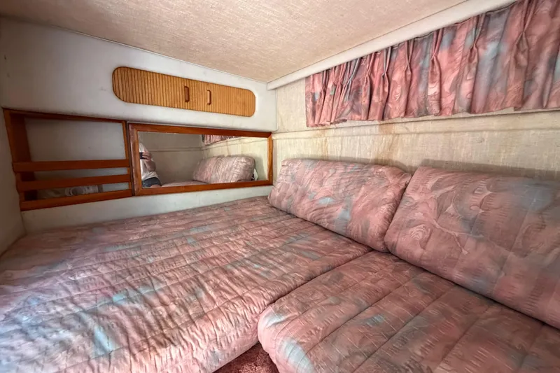 Slide: The Image of Interior cabin of 1989 Sea Ray Sundancer 280 with pink bedding and curtains. - 32
