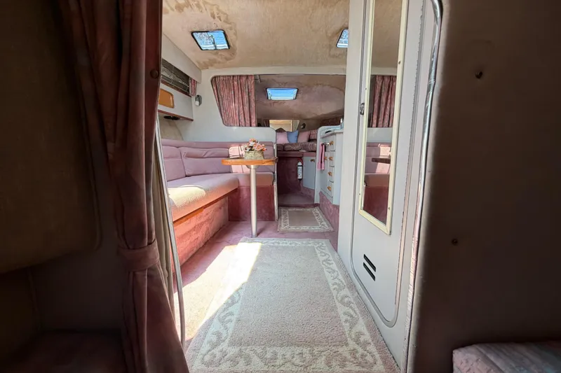 Slide: The Image of Interior of 1989 Sea Ray Sundancer 280, featuring cozy seating and elegant decor. - 34