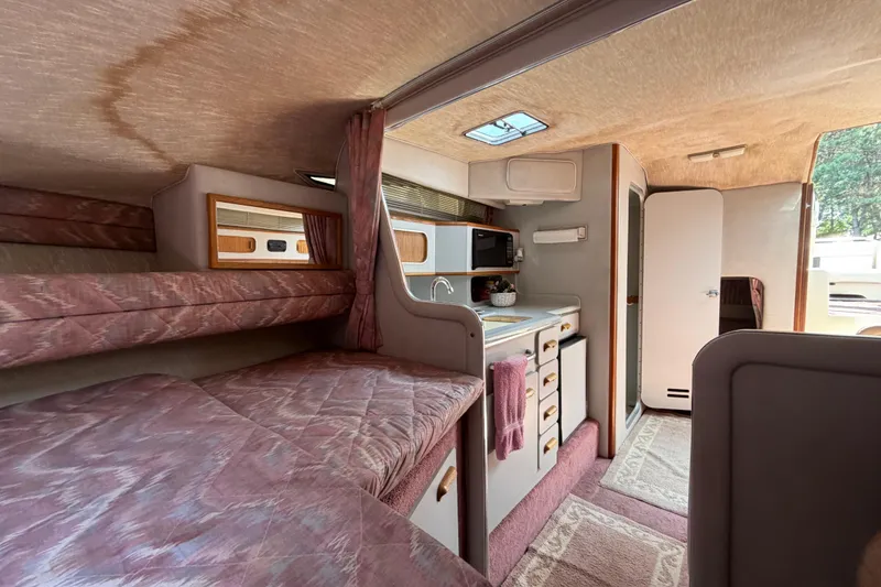 Slide: The Image of Interior of a 1989 Sea Ray Sundancer 280 boat, featuring cozy sleeping and kitchen areas. - 29